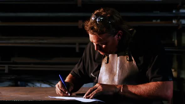 Welder working on blueprint alt