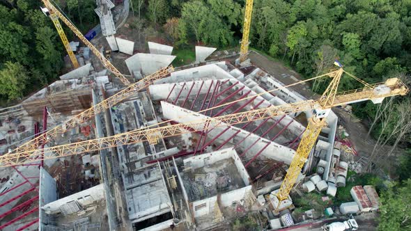Aerial View Construction of a New Building with High Tower Cranes in Green Area alt