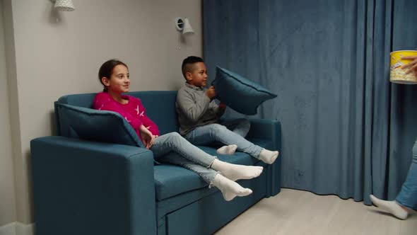 Single Mother with Two Multinational Children Watching TV at Home alt