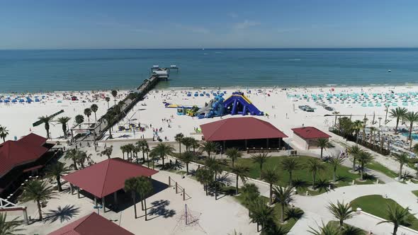 Aerial view of pavilions and palm trees on a beach alt