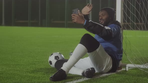 Man Video Calling on Soccer Field alt
