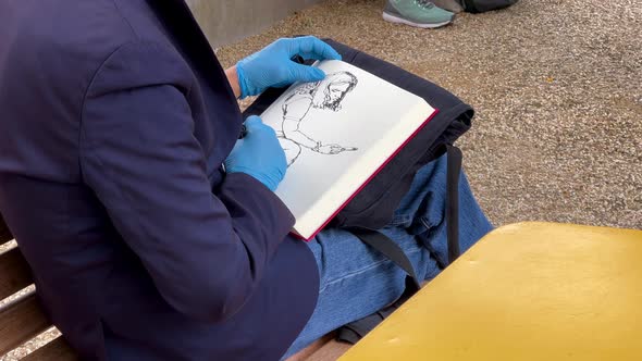 An Artist On A Bench Draws A Girl