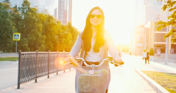 Modern city eco lifestyle, girl in sunglasses rides old vintage bicycle, carrying products from shop