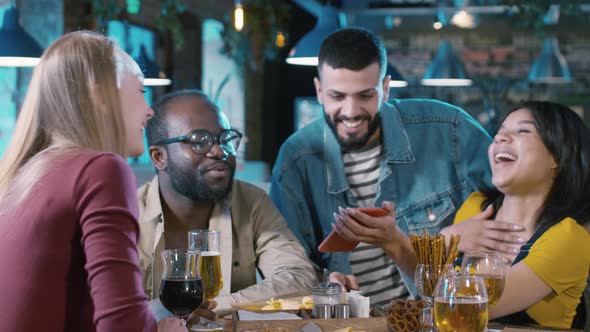 Friends discussing funny video on smartphone