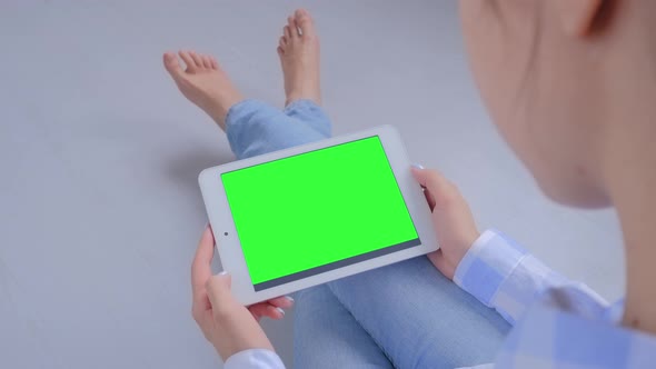 Woman Using Tablet Computer with Blank Green Screen  Chroma Key Concept