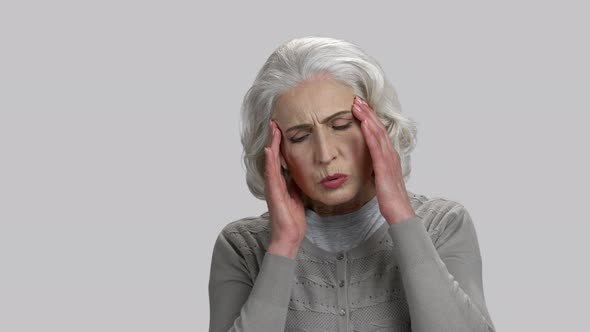 Old Lady Touching Her Temples Because of Headache alt
