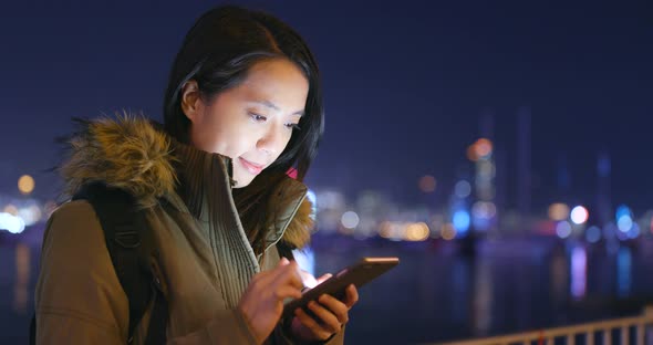 Asian woman use of smart phone in city at night alt