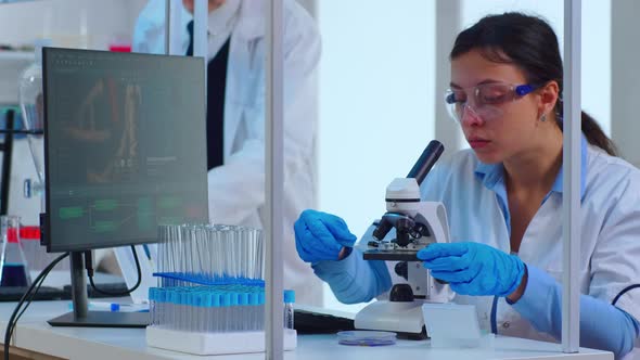 Woman Scientist Making Research Using Microscope alt