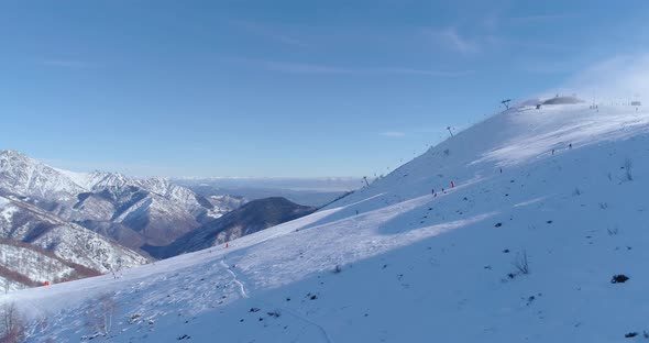 Side Aerial Follow People Skier Alpine Skiing in Winter Snowy Mountain Ski Track Field in Sunny Day