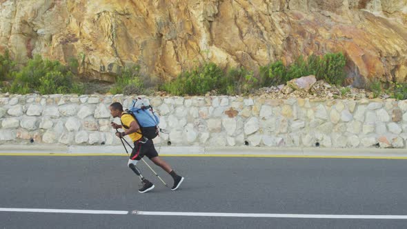 Sporty mixed race man with prosthetic leg hiking alt
