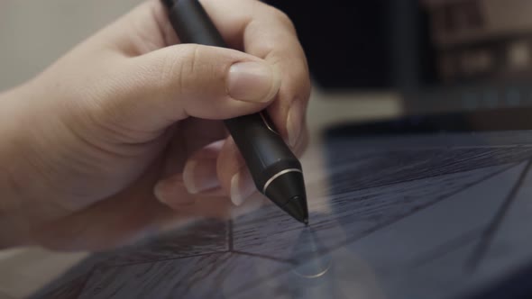 Closeup of woman hand using graphic pen stylus on a tablet, drawing design pattern