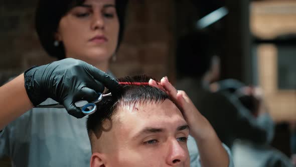 Barber Cuts the Hair of the Client with Scissors Close-up. Frame. Barber Combing Hair and Cutting alt