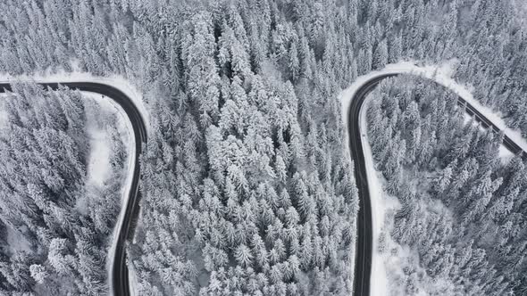 Canadian road in winter in the mountains. Aerial view of windy road. alt