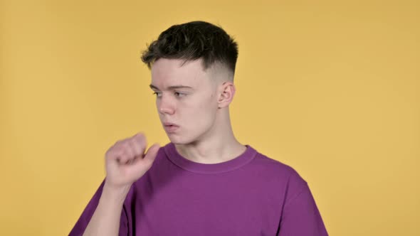 Sick Young Man Coughing on Yellow Background alt