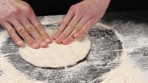 The Male Hands of the Chef Make a Blank for Italian Pizza From the Dough