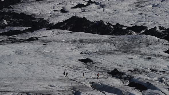 Long Shot of Tourist Groups Hiking Over Massive Glacier