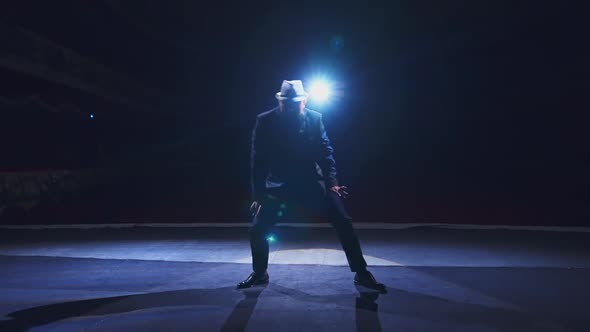 Senior man in costume on stage in darkness.  alt