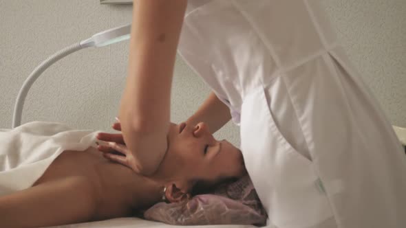 A Masseur Gives a Woman a Professional Facial Massage