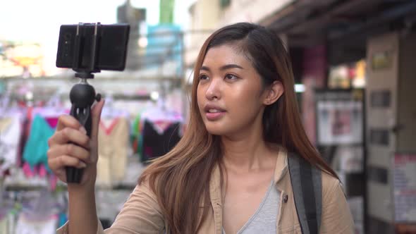 Young Female Tourist Holding a Gimbal with Smartphone and Recording Videos alt