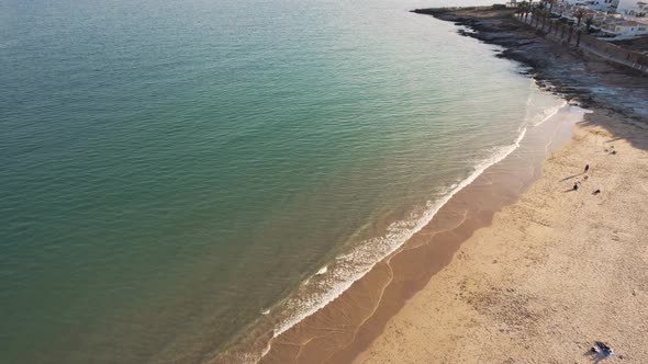 Praia da Luz seafront with golden beach sand in Algarve, Portugal. Aerial alt