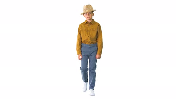 Boy in a Shirt Adjusting His Straw Hat While Walking and Looking at Camera on White Background