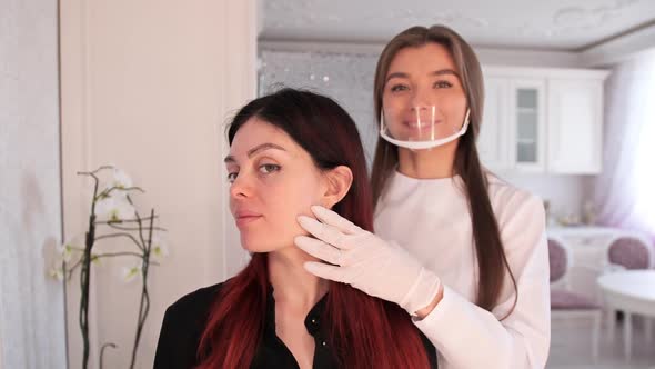 Makeup Artist and Client Look at the Painted Eyebrows in the Mirror alt