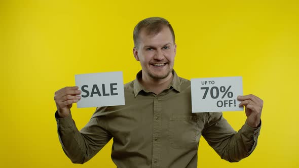 Cheerful Man Showing Sale Word and Showing Up To 70 Percent Off Inscription. Black Friday Concept alt