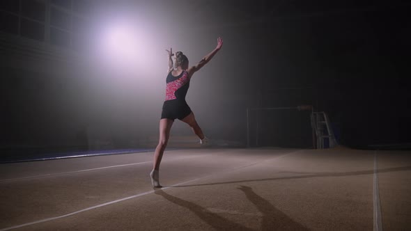 Female Gymnast is Performing Flips on Spring Floor Training in Gymnastic Hall Alone Artistic alt