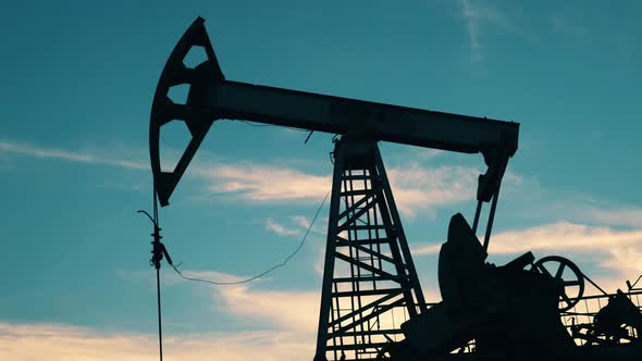Crude Oil, Gas, Petroleum Prices Concept. Pumpjack Is Pumping Oil with the Sky in the Background alt