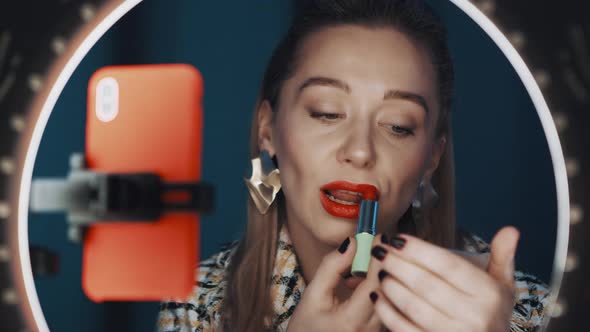 Attractive Woman Fashion Blogger Applies Lipstick in Front of Ring Light Online
