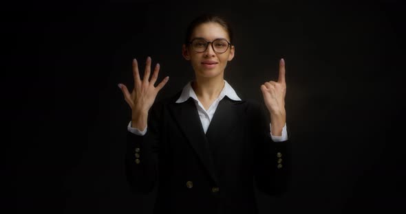 Business Woman Smiles at the Camera and Shows the Number Six with Her Fingers