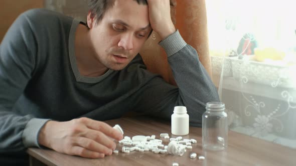 Man Has a Lot of Pills and Falls Asleep. The Concept of Depression, Suicide and Danger