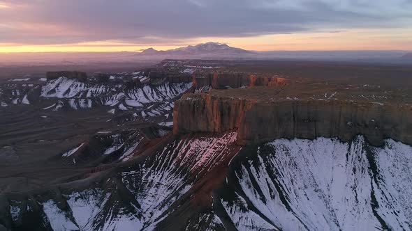 Rising aerial view of rugged desert landscape during sunrise in Utah alt