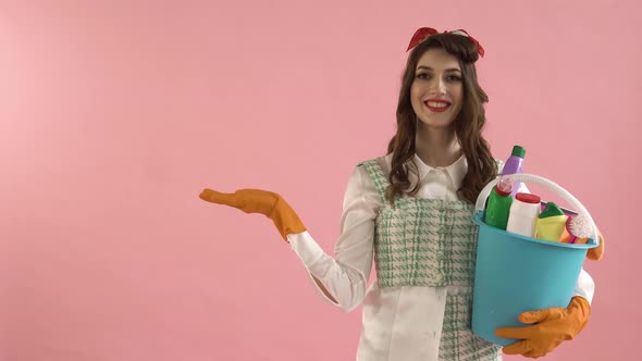 A Woman Holds a Bucket of Cleaning Tools and Points to a Place for Advertising