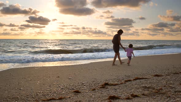 Mom and Daughter Walking on the Beach