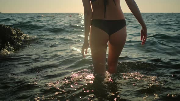 Woman is Entering in Sea and Swimming in Water in Summer alt
