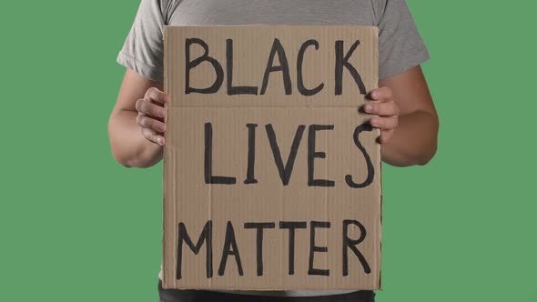 Man Holds in Front of Him a Poster From a Cardboard Box with the Words BLACK LIVES MATTER. Concept alt
