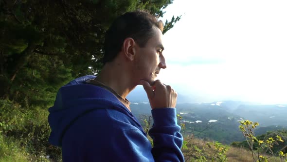 Pensive Man at the Edge of Mountains