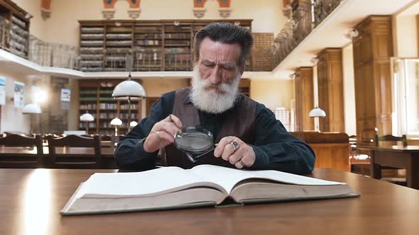 Old Intelligent Bearded Man Taking off His Glasses and Rubbing Eyes alt