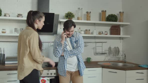 Cheater Man Talking on Smartphone in Kitchen alt