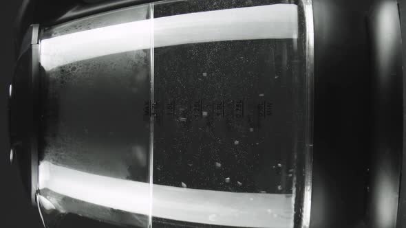 Vertical Video The Water in the Electric Kettle with Transperent Glass Walls Begins to Boil