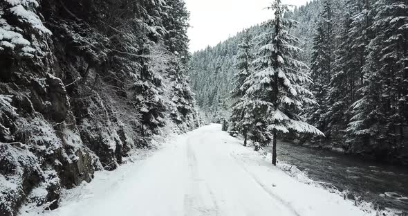 Mountain Road in the Alpine Mountains Snowcovered Forest a Mountain River Flows Nearby alt