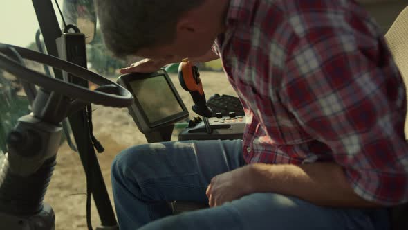 Harvester Operator Checking Machine Display Closeup alt