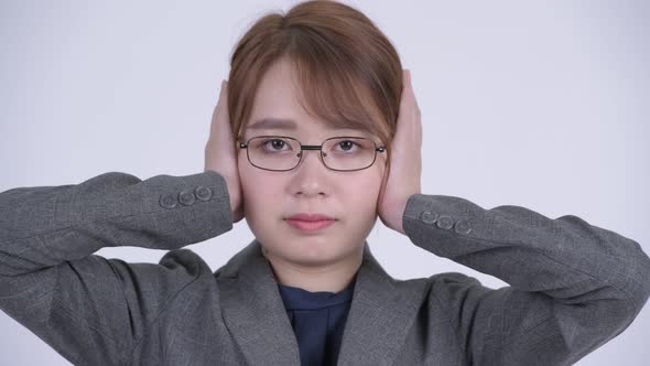 Face of Young Beautiful Asian Businesswoman Covering Ears As Three Wise Monkeys Concept alt