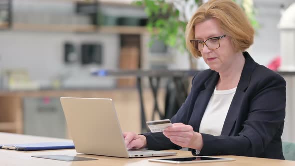 Old Businesswoman Having Online Payment Failure on Laptop in Office alt