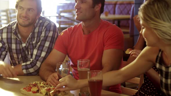 Friends interacting with each other while having pizza 4k alt