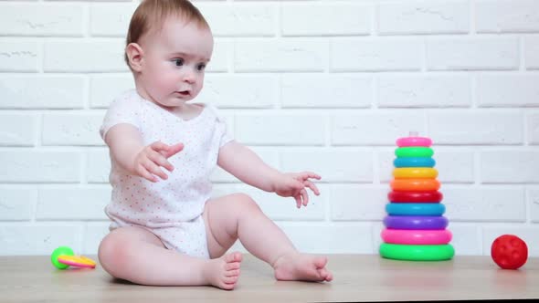 Cute baby girl playing with toy. Smart funny child. Top view alt
