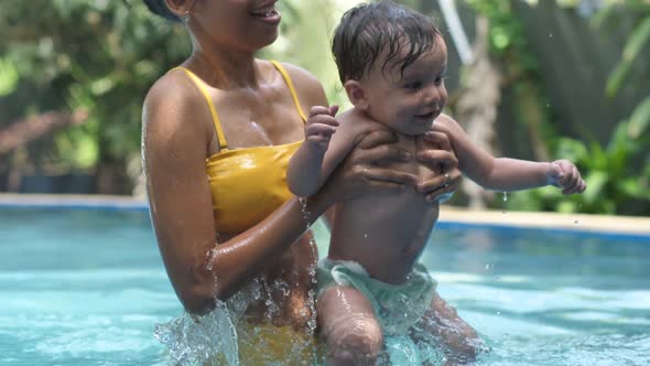Happy Young Asian Mother and a Baby Smiling and Jumping in the Swimming Pool