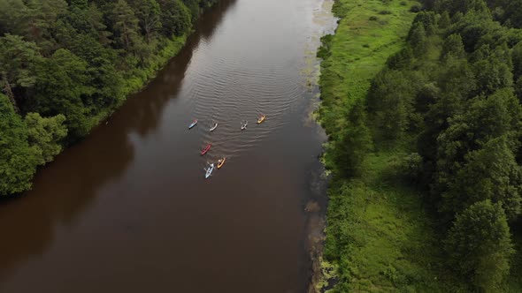 Aerial Flight Over a Group of Kayaks Floating Along the River in a Wedge