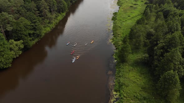 Aerial Flight Over a Group of Kayaks Floating Along the River in a Wedge